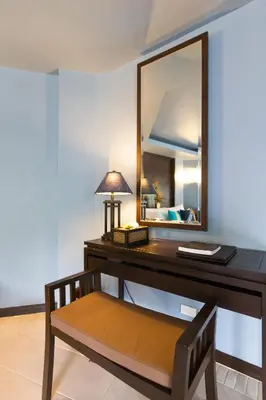 a desk with a mirror and a bench in a room at Peace Laguna Resort & Spa in Ao Nang Beach