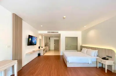 a bedroom with a white bed and a flat screen tv at Ramada by Wyndham Aonang Krabi in Ao Nang Beach