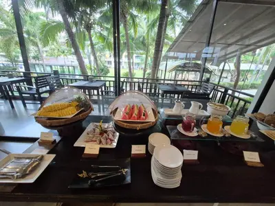 a table with plates of food and fruit on it at Ramada by Wyndham Aonang Krabi in Ao Nang Beach