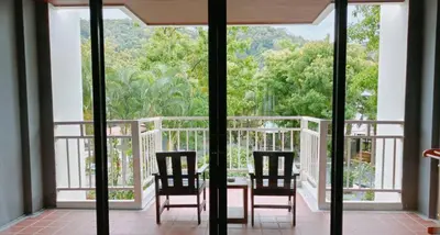 a balcony with two chairs and a table with a view at Ramada by Wyndham Aonang Krabi in Ao Nang Beach