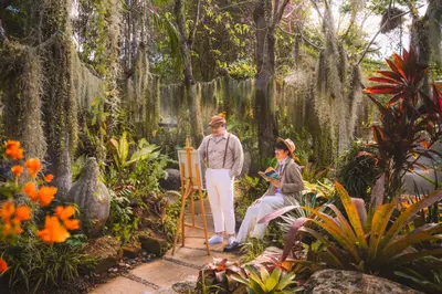 a man and a woman standing in a garden at Thavorn Palm Beach Resort Phuket in Karon Beach