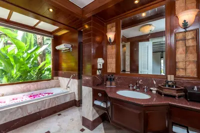 a bathroom with a tub and a sink and a mirror at Thavorn Beach Village Resort & Spa Phuket in Kamala Beach