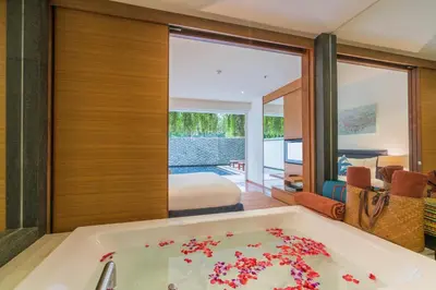 a bathroom with a bath tub with flowers in it at The Chava Resort in Surin Beach
