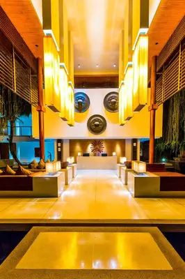 a hotel lobby with a long table and chairs at The Chava Resort in Surin Beach