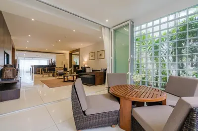 a living room with a table and chairs at The Chava Resort in Surin Beach