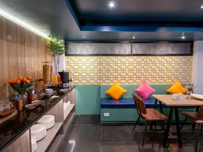a dining room with a table and colorful pillows at MORE Patong Hotel in Patong Beach