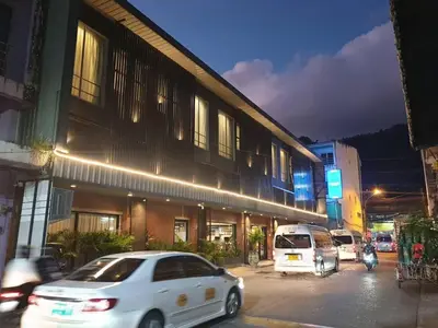 a white car parked in front of a building at night at MORE Patong Hotel in Patong Beach