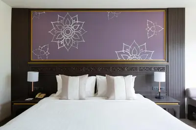 a bedroom with a large bed with white pillows at Krabi Heritage Hotel in Ao Nang Beach