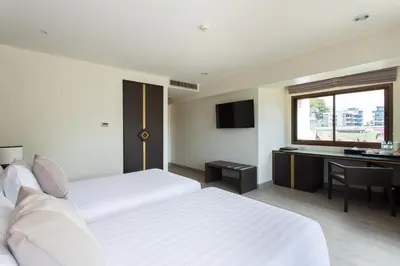 a hotel room with two beds and a desk at Krabi Heritage Hotel in Ao Nang Beach