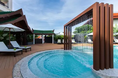 a swimming pool with a patio and an umbrella at Krabi Heritage Hotel in Ao Nang Beach