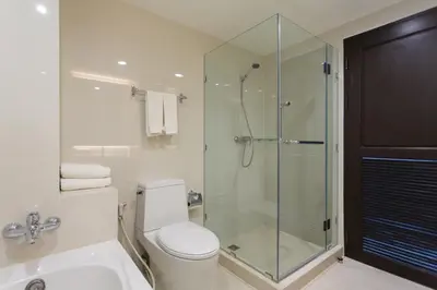 a bathroom with a toilet and a glass shower at Krabi Heritage Hotel in Ao Nang Beach
