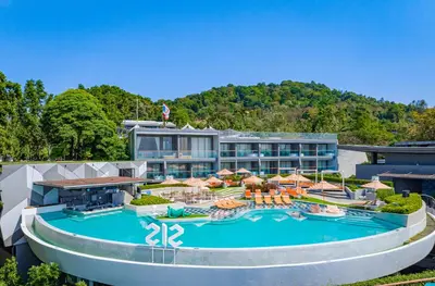 a resort with a large pool with chairs and umbrellas at The SIS Kata Resort - Adult Only in Kata Beach