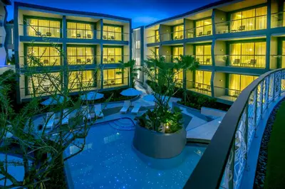an apartment building with a balcony at night at The SIS Kata Resort - Adult Only in Kata Beach