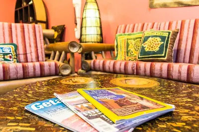 a table with magazines on top of it with chairs at Chaba Pool Villa Private Tropical Villa With Pool in Nai Harn Beach
