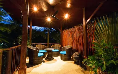 a patio with chairs and a table and a fence at Chaba Pool Villa Private Tropical Villa With Pool in Nai Harn Beach