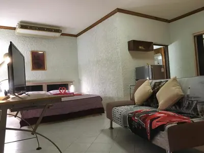 a bedroom with a bed and a desk and a couch at Peaceful homestay in Rawai Beach