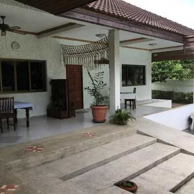 a porch of a house with a table and chairs at Peaceful homestay in Rawai Beach