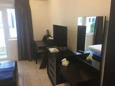 a hotel room with a bedroom with a desk and a bed at Cafe de Paris in Patong Beach