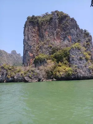 a small island in the water next to a mountain at Kata S. T. House in Kata Beach