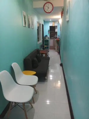 a living room with a couch and chairs and a clock at Kata S. T. House in Kata Beach
