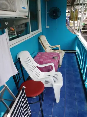 a row of chairs and a table on a balcony at Kata S. T. House in Kata Beach
