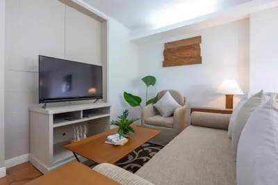 a living room with a couch and a tv at Kantary Bay Hotel Phuket in Panwa Beach