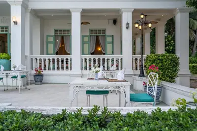 a white table and chairs on a house at Cape Panwa Hotel Phuket in Panwa Beach