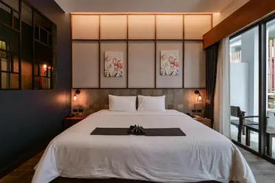 a bedroom with a bed with a black bow on it at R-Mar Resort and Spa Patong, Phuket in Patong Beach