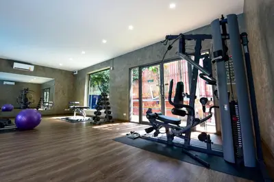 a gym with treadmills and exercise equipment in a room at R-Mar Resort and Spa Patong, Phuket in Patong Beach