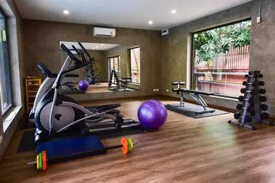 a gym with exercise equipment and a large mirror at R-Mar Resort and Spa Patong, Phuket in Patong Beach