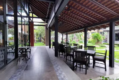 a dining area with tables and chairs and windows at R-Mar Resort and Spa Patong, Phuket in Patong Beach