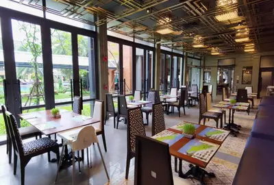 a restaurant with tables and chairs and windows at R-Mar Resort and Spa Patong, Phuket in Patong Beach
