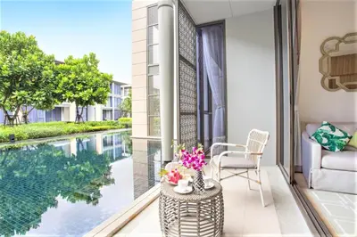 a balcony with a view of a swimming pool at Luxury Oceanfront_pool access apartment in Mai Khao Beach