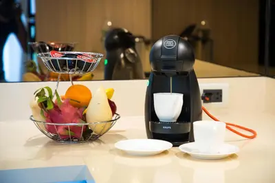 a coffee maker sitting on a counter next to a bowl of fruit at Luxury Oceanfront_pool access apartment in Mai Khao Beach