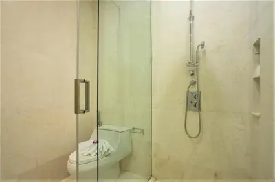 a bathroom with a shower with a toilet at Luxury Oceanfront_pool access apartment in Mai Khao Beach