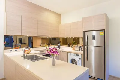 a large kitchen with a stainless steel refrigerator at Luxury Oceanfront_pool access apartment in Mai Khao Beach