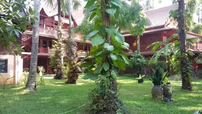 a house with a bunch of trees in the yard at Royal Phawadee Village Patong - 2 Minutes walk to the beach in Patong Beach