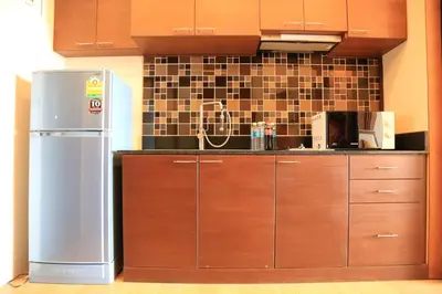 a kitchen with wooden cabinets and a refrigerator at Sea and Sky Condominium Room #406 in Karon Beach