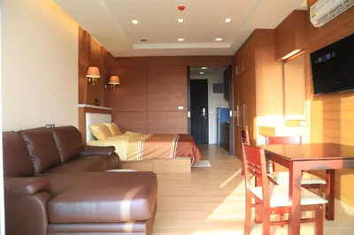 a bedroom with a bed and a couch and a table at Sea and Sky Condominium Room #406 in Karon Beach