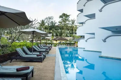 a pool at a resort with lounge chairs and umbrellas at Krabi La Playa Resort in Ao Nang Beach