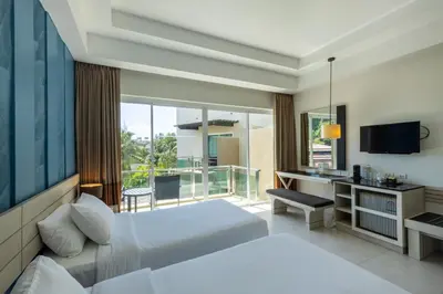 a hotel room with a bed and a balcony at Navinda Krabi in Ao Nang Beach