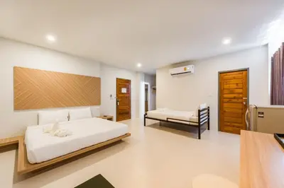a bedroom with a bed and a chair in it at Phuket Marine Poshtel - SHA Plus in Chalong