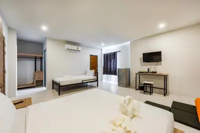 a living room with a couch and a tv at Phuket Marine Poshtel - SHA Plus in Chalong