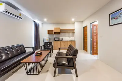 a living room with a couch and chairs and a table at Phuket Marine Poshtel - SHA Plus in Chalong