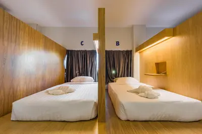 two beds in a hotel room with two bedsvisor at Phuket Marine Poshtel - SHA Plus in Chalong