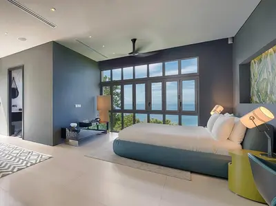 a bedroom with a large bed and a large window at Malaiwana Villas in Nai Thon Beach