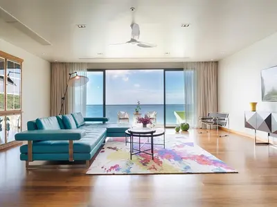 a living room with a blue couch and a table at Malaiwana Villas in Nai Thon Beach