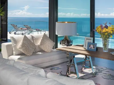 a living room with a couch and a table with a lamp at Malaiwana Villas in Nai Thon Beach