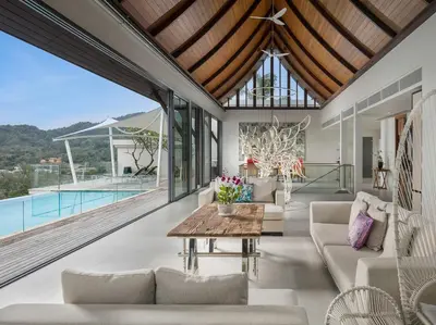 an open living room with a view of a pool at Malaiwana Villas in Nai Thon Beach