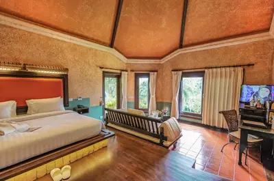 a bedroom with a large bed and a television at Mangosteen Ayurveda & Wellness Resort - SHA Plus in Rawai Beach